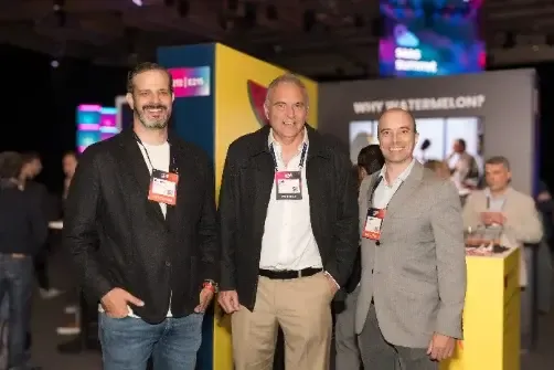 Tres miembros del equipo posan frente al estand en el Web Summit